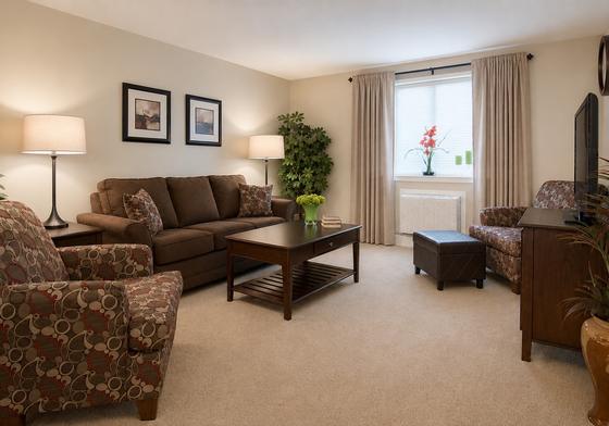 Furnished living room with sofa and armchairs in a J.E. apartment