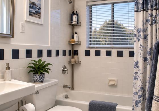 Full bathroom with blue tile in a J.E. Waltham apartment